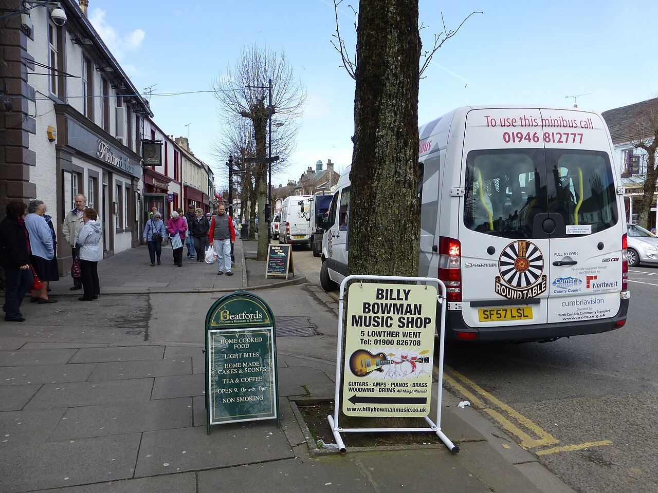 Looking along Cockermouth's broad Main Street with Georgian shopfronts and trees